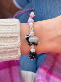 a close up of a person's arm wearing a bracelet with beads and charms