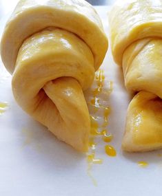 two doughnuts that have been rolled up on a cutting board with honey drizzled around them