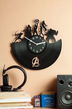 a clock that is on the side of a wall next to some books and speakers