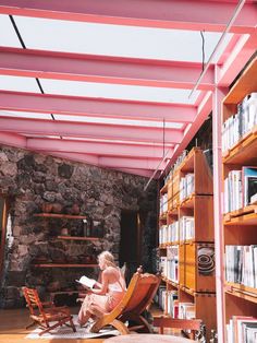 a woman sitting on a chair in front of a bookshelf filled with books