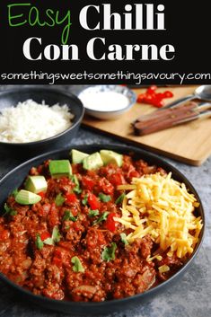 an easy chili con carne with cheese and avocado on top in a skillet