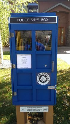 a blue police box sitting in the grass