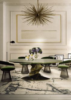 an elegant dining room with green chairs and a chandelier