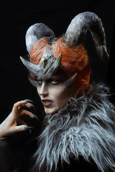 a woman with red hair and horns on her head wearing an animal - like costume