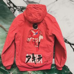 a red jacket with an image of a man on it sitting on a marble floor