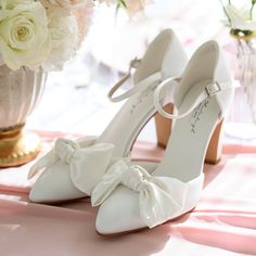 Very elegant and special bridal shoes. 8,7 cm block heels. Very comfortable padded insole and off-white satin exterior with bows. Closed toe. Regular sizes. If you have questions, please contact us. Feminine Low Heel Wedding Shoes With Heel Strap, Feminine Wedding Shoes With Low Heel And Heel Strap, Feminine Wedding Shoes With Heel Strap And Low Heel, Feminine Wedding Shoes With Heel Strap, Feminine Wedding Shoes With Heel Strap And Round Toe, Low Heel Strap Heels For Bridal Shower, Formal Wedding Shoes With Ankle Strap And Bow, Feminine Heels With Heel Strap For Wedding, Elegant Wedding Shoes With Wrapped Heel For Bridal Shower