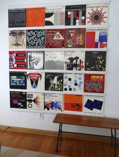 a wall with many different types of posters on it and a table in front of it