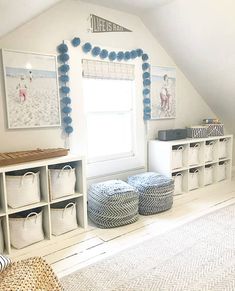 a room with white walls, blue and white baskets on the floor and hanging decorations