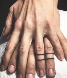 two people's hands with black ink on their fingers and one has a small tattoo