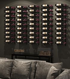 a living room filled with furniture and lots of wine bottles hanging on the wall next to a couch