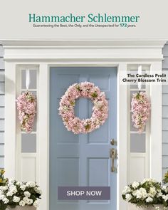 the front door is decorated with pink flowers and wreaths on it's sides