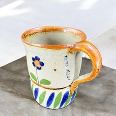 there is a coffee cup that has been decorated with flowers and leaves on the inside