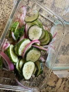 sliced cucumbers and onions in a glass container