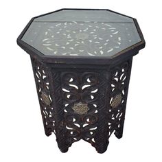 an ornate wooden table with glass top