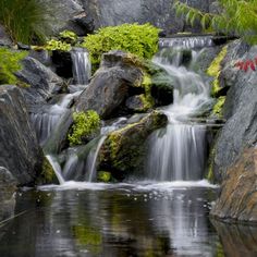 there is a small waterfall in the middle of some rocks