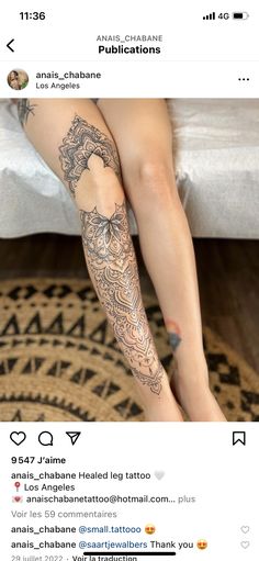 a woman's legs with tattoos sitting on top of a bed