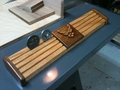 a wooden cutting board sitting on top of a table next to a knife and some scissors