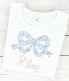 This precious monogram embroidered shirt or bodysuit has cute blue appliqué bow with floral accents & your little girl's name below. Our white boutique shirts and bodysuites are the highest quality on the market. They are thick & beautifully constructed. They run true to size. We recommend to size up if in between sizes. Free Monogram Fonts, White Boutique, Girl Embroidery, Baby Girl Toddler, Boutique Shirts, Panama City Beach Fl, Free Monogram, Shirt Bodysuit