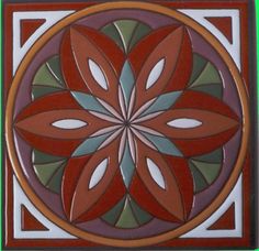 an artistic tile design in red, green and brown colors on a white wall or floor