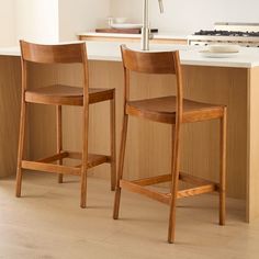 two wooden chairs sitting in front of a counter