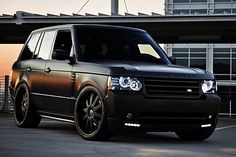 a black range rover parked in front of an airport