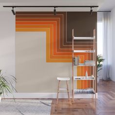 an orange and brown wall mural in a living room with a ladder next to it