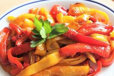 a white plate topped with red and yellow peppers