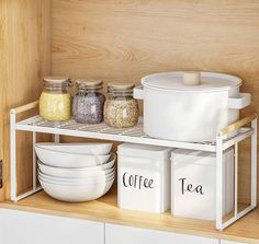 the shelves are organized with cups, bowls and containers for tea or other things to drink