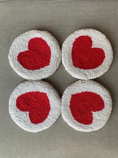 four coasters with hearts on them sitting on a gray tablecloth covered surface in the shape of circles