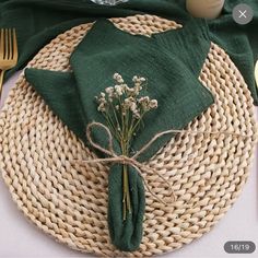 a place setting with green napkins and flowers