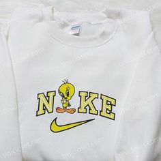 Introducing the Nike x Tweety Cartoon Embroidered Sweatshirt, a playful collaboration that combines the iconic Nike brand with the beloved Looney Tunes character, Tweety Bird. This sweatshirt features a high-quality embroidered design of Tweety on the front, adding a touch of nostalgia and charm to your wardrobe. The Disney Characters Embroidered T-shirt is a must-have for any Disney lover. Made from soft and breathable fabric, this t-shirt showcases a collection of your favorite Disney characte Nike Cartoon, Nightmare Before Christmas Hoodie, Nike Inspired, Dc Comics Shirts, Best Family Gifts, Kitty Accessories, Embroidered Shirts, Cartoon Embroidery, Beating Heart