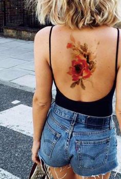 the back of a woman's body with flowers painted on her upper and lower back