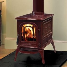 a wood burning stove sitting on top of a black mat