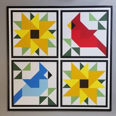 four different colored birds are displayed on the wall