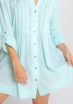 Ultra-relaxed and flowy, this effortless tunic top is our go-to style for any season. Featuring long rolled sleeves with a button tab closure, pintuck front details, and a button-up front. The raw edge hemline adds a lived-in feel. Tunic shirt Relaxed, oversize fit Long rolled sleeve with button tab closure Long tunic length Collared neckline Button front Raw-edge hem Side pockets Pintuck details Sheer Cotton Spring top Model is 5'9, wearing a size S/M.Style: I-13929W-RUU Casual Tunic Blouse With Buttons, Spring Beach Top With Placket, Spring Daywear Blouse With Roll-up Sleeves, Summer Tunic Blouse With Buttons, Summer Long Sleeve Blouse With Buttons, Casual Tunic With Button Closure For Daywear, Spring Buttoned Tunic Top, Spring Button Tunic Top, Spring Tunic Top With Buttons