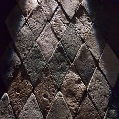 a close up view of some kind of stone pattern on a wall with sunlight coming through the window