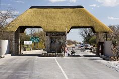 an open road with a thatched roof over it