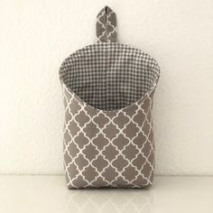 a gray and white bag sitting on top of a counter next to a white wall