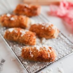 some food that is sitting on a wire rack with powdered sugar sprinkles