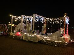 some people are riding in a float decorated with lights