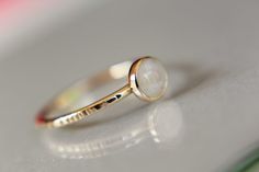 "This flash rainbow moonstone ring has a subtle, lux feel to it. I have set this 5mm round smooth rainbow moonstone gemstone into a solid 14kt yellow bezel cup with a thicker band ring. The 16 gauge solid 14kt yellow band has been also highly polished for a very reflective shine. This listing is for 1, 5mm rainbow moonstone ring. Material Information: Clarity: Occlusioned Color: rainbow Gemstone: moonstone Metal: 14kt yellow gold Handcrafted band: 16 gauge (1.4mm) faceted Please contact me with Minimalist Round Moonstone Opal Ring, White Moonstone Stackable Rings For Promise, White Moonstone Stackable Ring With Round Band, Dainty White Moonstone Ring With Round Band, White Crystal Ring With Moon Phase, White Moon Phase Crystal Ring, Minimalist Moonstone Ring With Bezel Setting, White Moonstone Stackable Rings, Minimalist Round Moonstone Ring With Bezel Setting