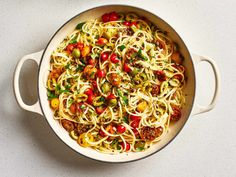 a pan filled with pasta and vegetables on top of a table