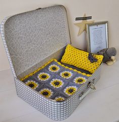 an open suitcase sitting on top of a white table next to a stuffed animal and frame