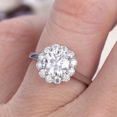 a woman's hand with a diamond ring on top of her finger and an engagement band