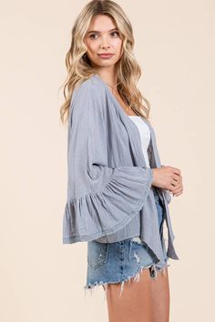 This light denim open front cardigan exudes elegance with its shawl collar and delicate lace trim. The ruffle trim sleeves and light blue color add to its unique charm. 100% Cotton Blue Bohemian Open Front Cardigan, Cozy Light Blue Spring Cardigan, Light Blue V-neck Cardigan For Winter, Lilac Shawl Collar Cardigan, Light Blue Button-up Cardigan With Button Closure, Athleisure Shoes, Open Front Cardigan, Denim Leggings, Light Blue Color