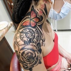 a woman with a tattoo on her arm and shoulder is sitting in front of a mirror