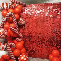 red and white balloons are hanging on the wall in front of an orange sequin backdrop