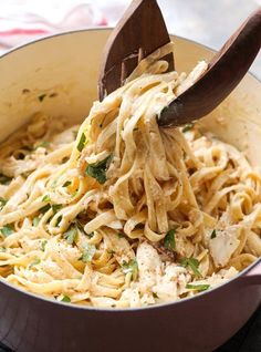 a wooden spoon scooping pasta out of a pot