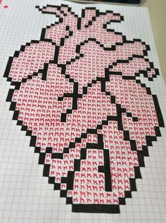 a cross stitched heart on top of a piece of paper