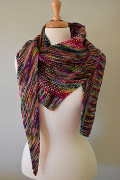 a white mannequin wearing a multicolored knitted scarf